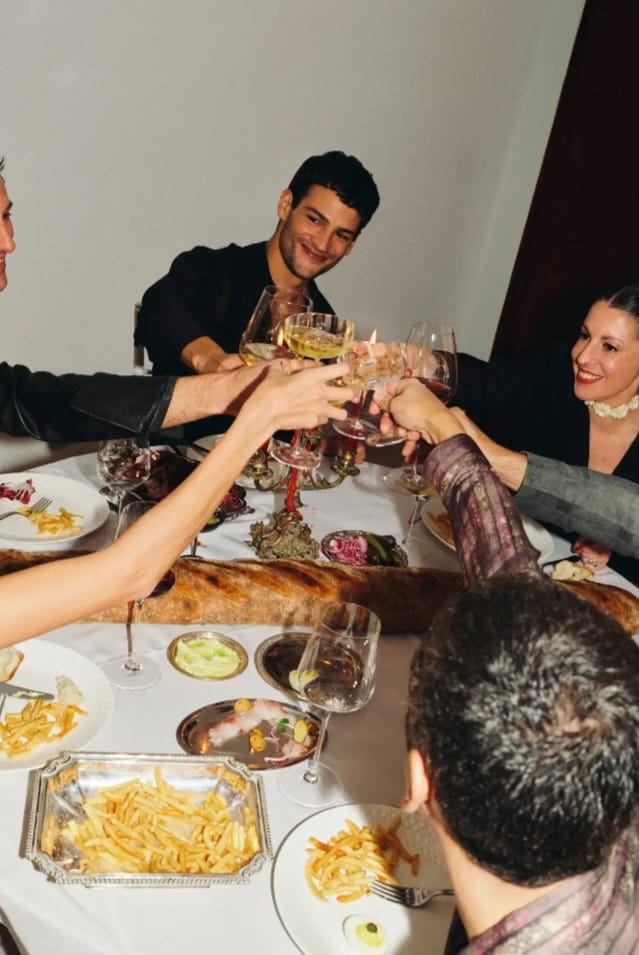 Guests in warm conversation around a candlelit table